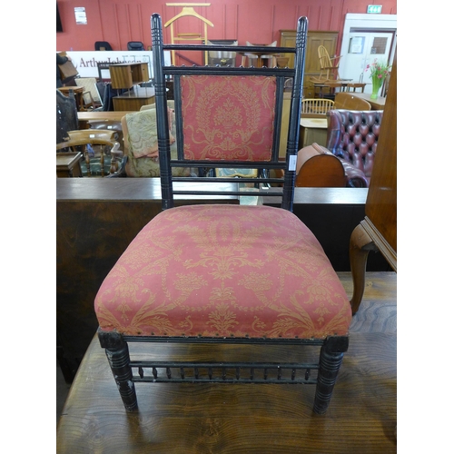 299 - An Arts and Crafts ebonised fire side chair, manner of E.W. Godwin