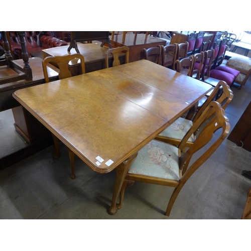 301 - A Queen Anne style burr walnut extending dining table and six chairs