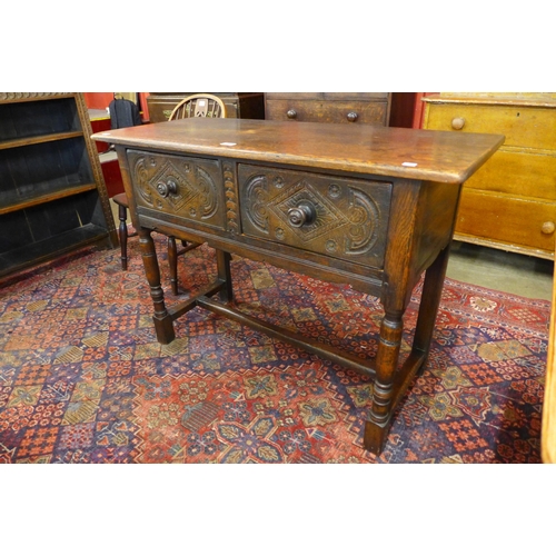 8 - A Jacobean Revival carved oak two drawer dresser