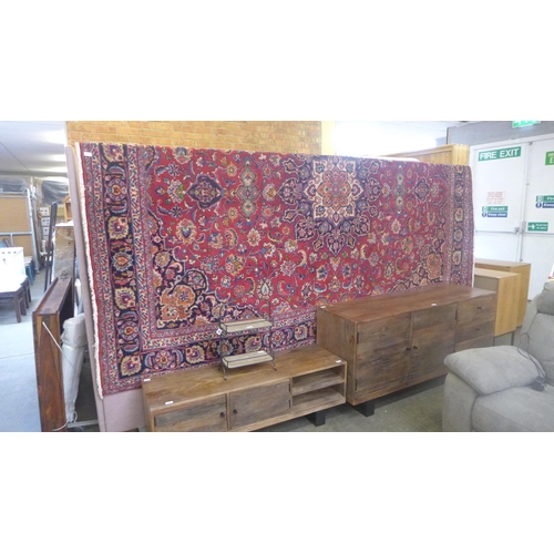 1558 - A Red ground, hand woven Persian Mashad carpet, multicoloured floral design 337 x 246cm