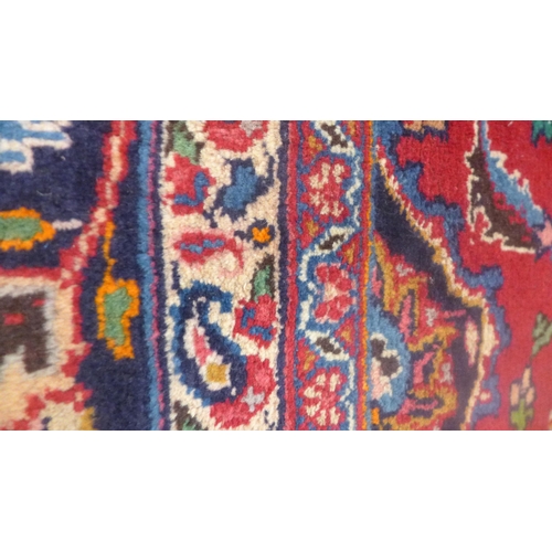 1558 - A Red ground, hand woven Persian Mashad carpet, multicoloured floral design 337 x 246cm