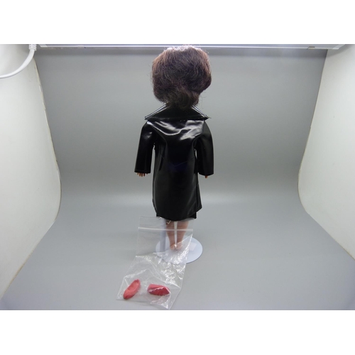 832 - A 1960's Sindy in black plastic coat with shoes, on stand