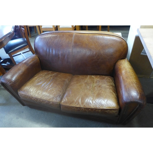 1607 - A brown leather two seater sofa