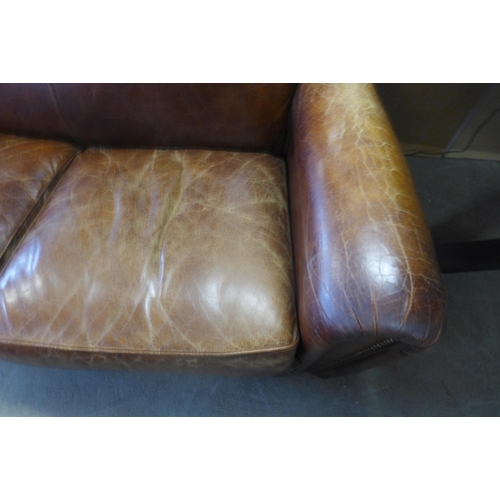 1607 - A brown leather two seater sofa