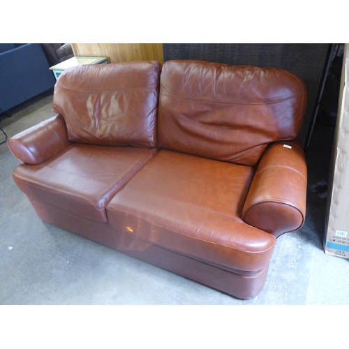 1650 - A tan leather two seater sofa