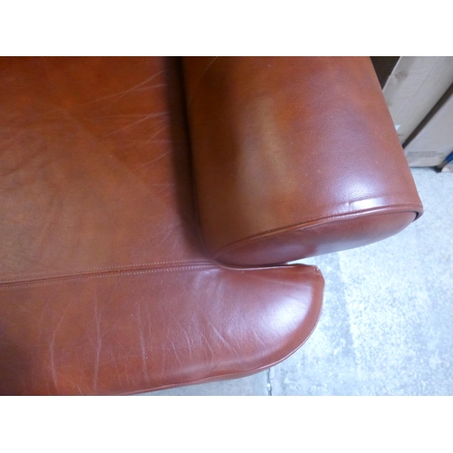 1650 - A tan leather two seater sofa