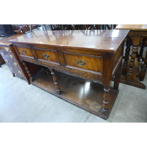 188 - A Jacobean Revival carved oak three drawer dresser