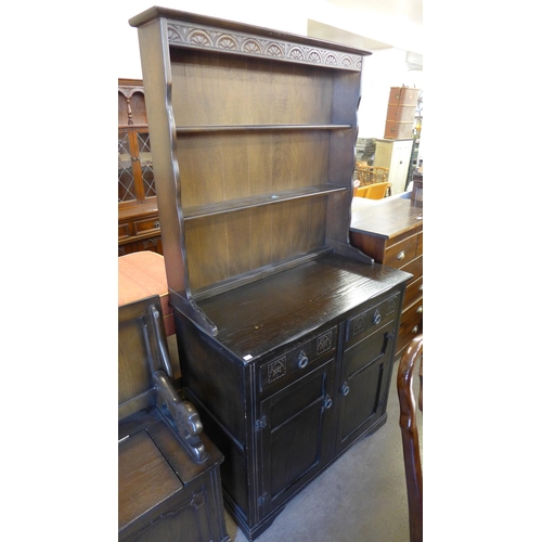 236 - A carved oak dresser and a monk's bench