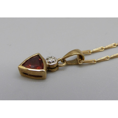 872 - A 9ct gold, diamond and red stone pendant and chain, 2.1g