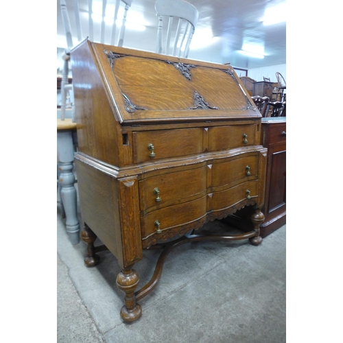 104 - An early 20th Century carved oak cantilever action bureau