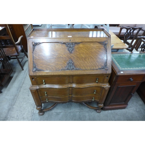 104 - An early 20th Century carved oak cantilever action bureau