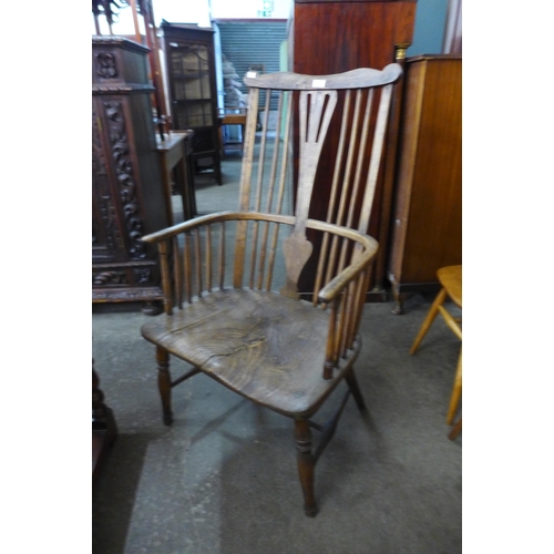 112 - A primitive 19th Century elm and beech comb back Windsor armchair