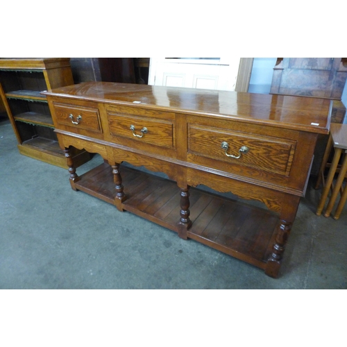 130 - A George III style oak three drawer dresser