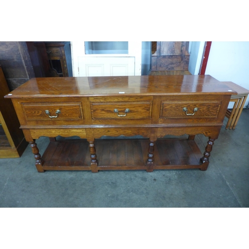 130 - A George III style oak three drawer dresser