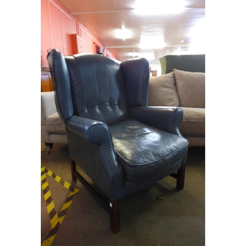 134b - A mahogany and blue leather wingback armchair