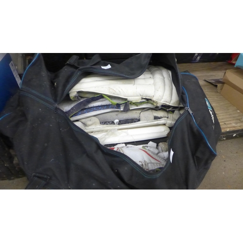 2082 - Large quantity of cricket pads & helmet with 2 bags