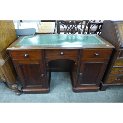 112 - A Victorian mahogany and green leather topped kneehole desk