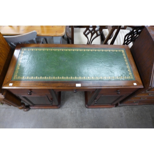 112 - A Victorian mahogany and green leather topped kneehole desk