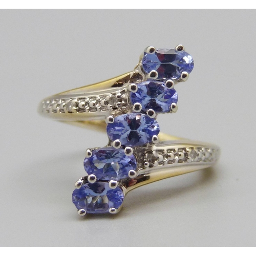 960 - A silver gilt, five stone tanzanite ring with diamond accents, L
