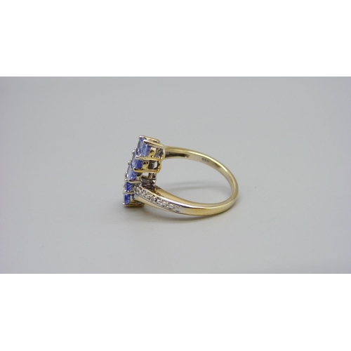 960 - A silver gilt, five stone tanzanite ring with diamond accents, L