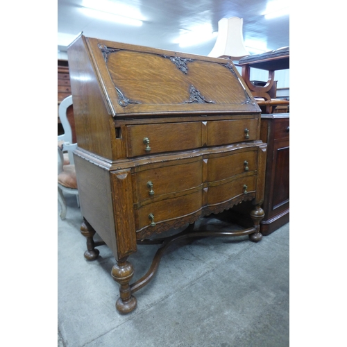 110 - An early 20th Century carved oak cantilever action bureau