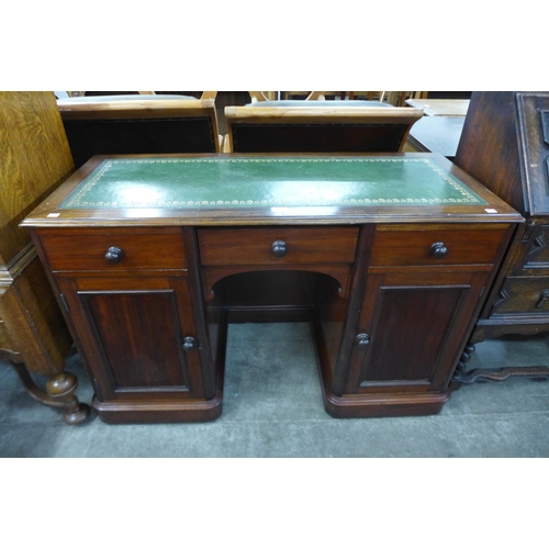 112 - A Victorian mahogany and green leather topped kneehole desk