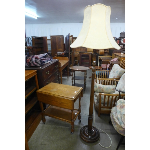 134 - An oak drop leaf trolley and an oak standard lamp