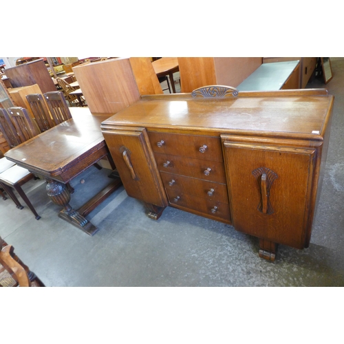 147 - A carved oak draw-leaf table and a sideboard