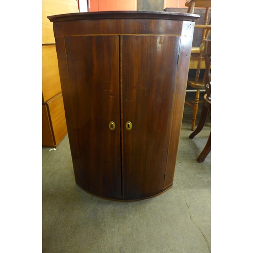 235a - A George III mahogany wall hanging corner cupboard