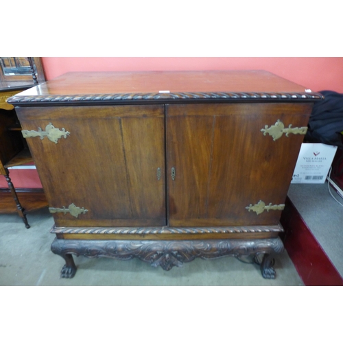 89 - A Chippendale Revival carved mahogany press cupboard on a stand