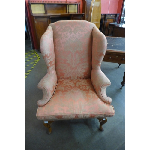 99 - A Queen Anne style walnut and fabric upholstered wingback armchair