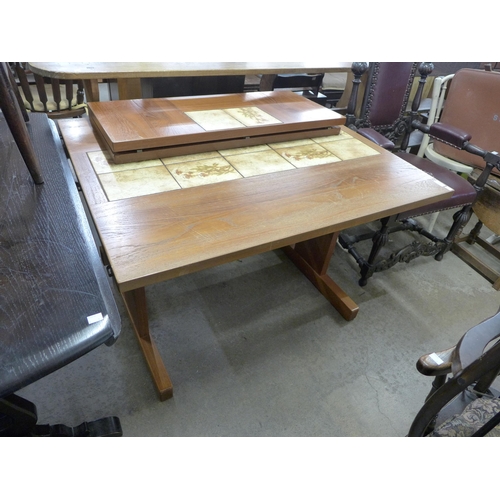 211 - A Danish teak and tiled top extending dining table and a simulated teak room divider