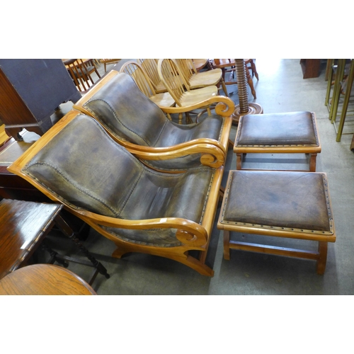 111 - A pair of hardwood and leather upholstered open armchairs and matching footstools