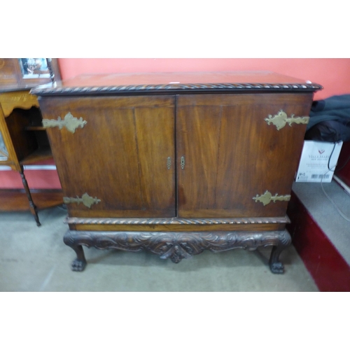 15 - A Chippendale Revival carved mahogany press cupboard on a stand