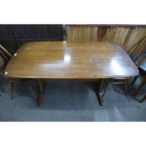 93 - An Ercol Golden Dawn elm and beech refectory table and four chairs