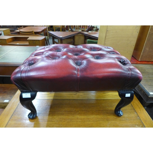 99 - A mahogany and buttoned red leather footstool