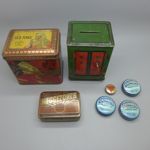 655 - A novelty money bank in the form of a safe, an Old Judge tin and five other tins