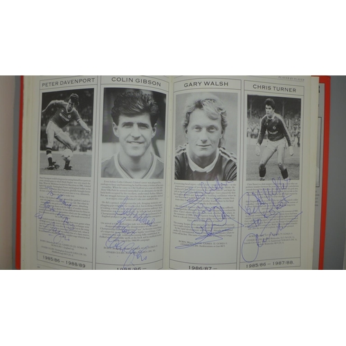 702 - Manchester United; a player by player book containing approximately 97 signatures from former player... 