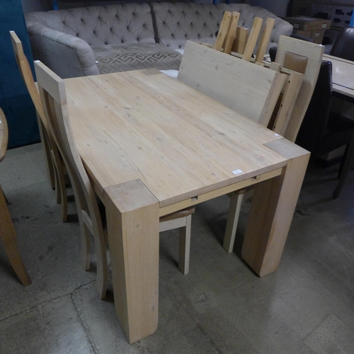 1752 - An oak extending dining table and four leather padded chairs