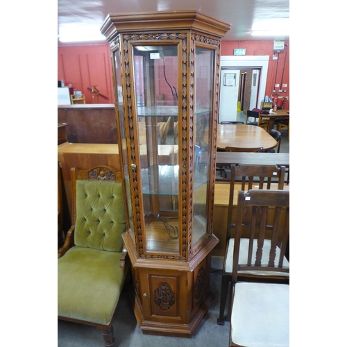 599 - A carved hardwood hexagonal display cabinet