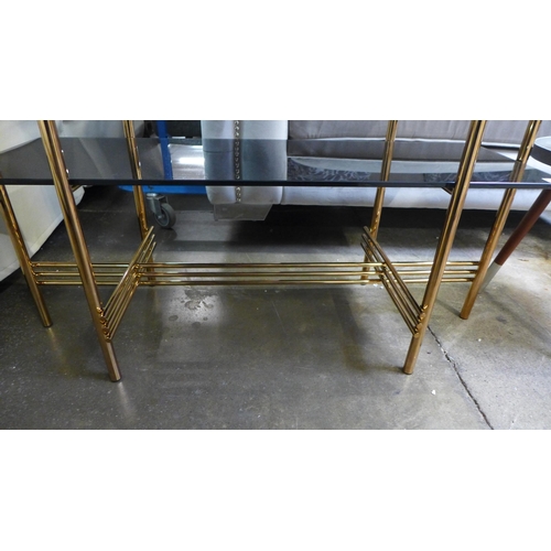 1329 - A gold and black glass two tier console table