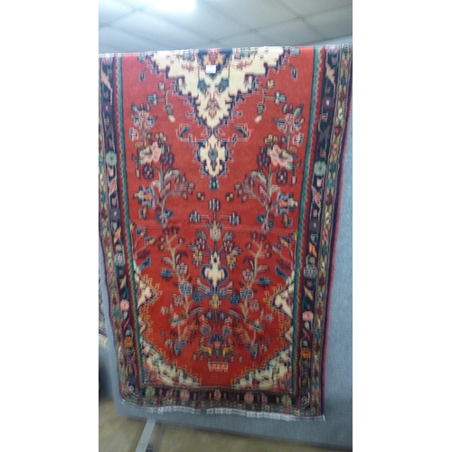 1558 - A red ground Persian Hamadan runner with floral design