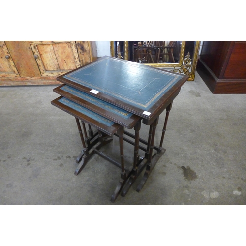 148 - A mahogany and blue leather topped nest of tables