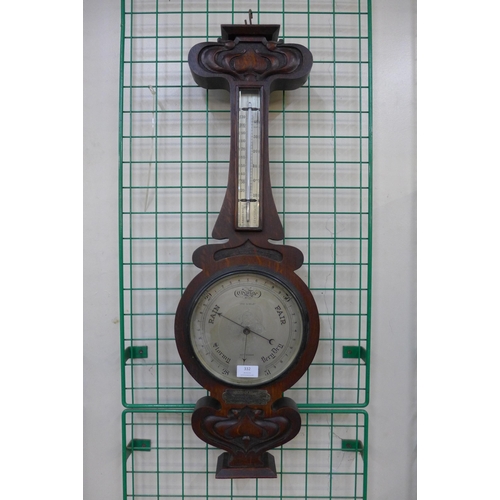 299 - An Art Nouveau oak aneroid barometer, the silvered dial signed Gray & Selby, Nottingham