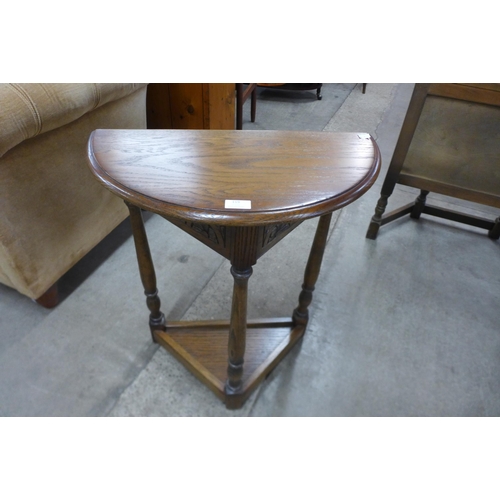 119 - A carved oak demi-lune side table