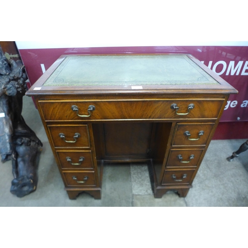 16 - A mahogany and green leather topped kneehole desk