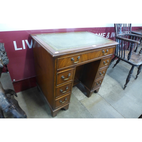 16 - A mahogany and green leather topped kneehole desk