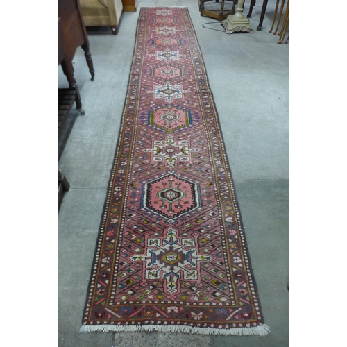 166 - A Persian salmon pink ground runner rug, 410 x 74cms