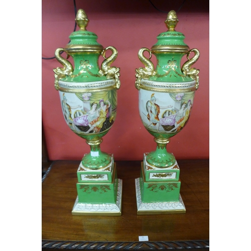 22 - A pair of Italian style green porcelain and gilt vases and covers, decorated with romantic scenes