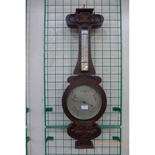 299 - An Art Nouveau oak aneroid barometer, the silvered dial signed Gray & Selby, Nottingham